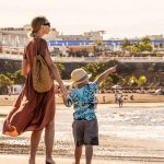 une mère avec son fils marchant sur la plage de sable fin à Tenerife